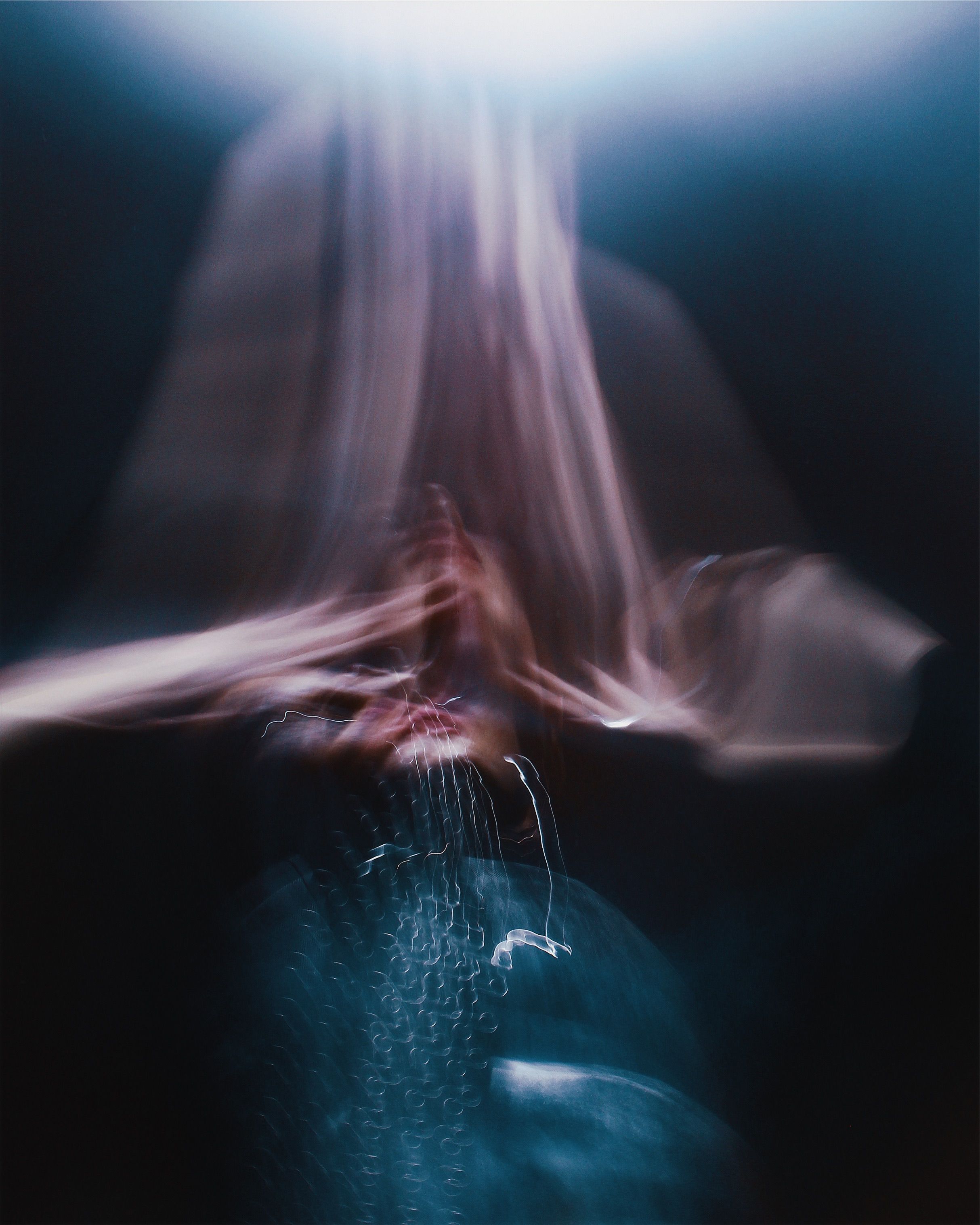 Long-exposure portrait dissolving into streaks of warm and cool light