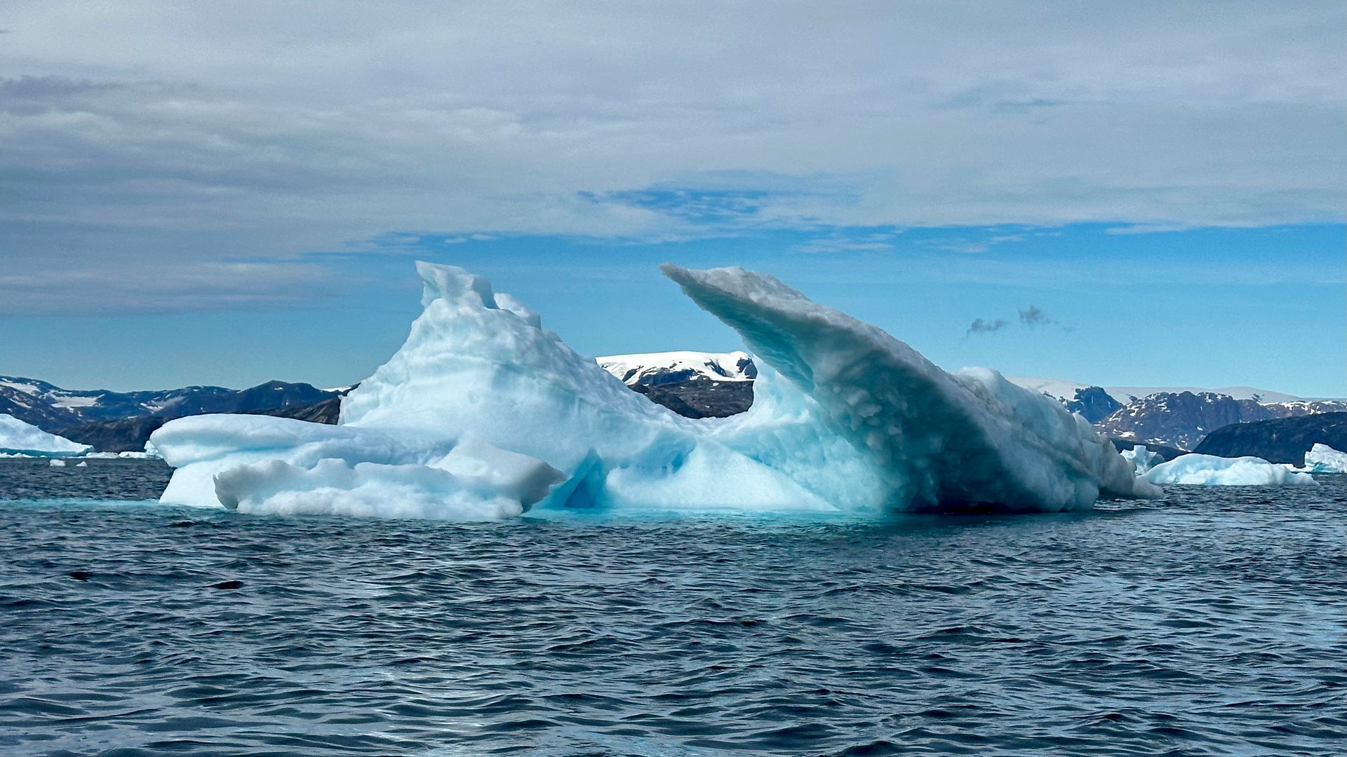 A glacier landscape of blue-white ice under a cold sky