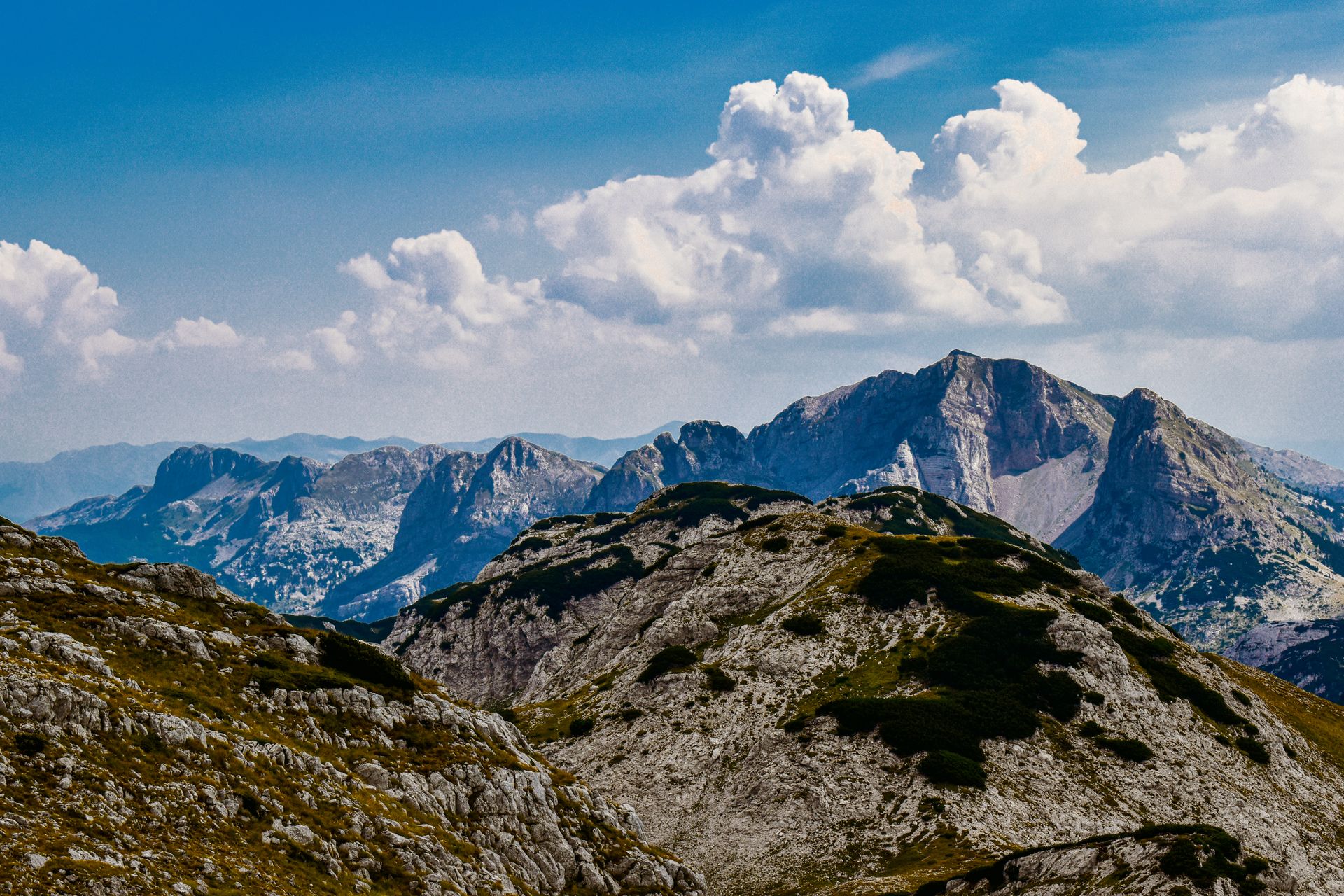 A sweeping alpine mountain range under dramatic light