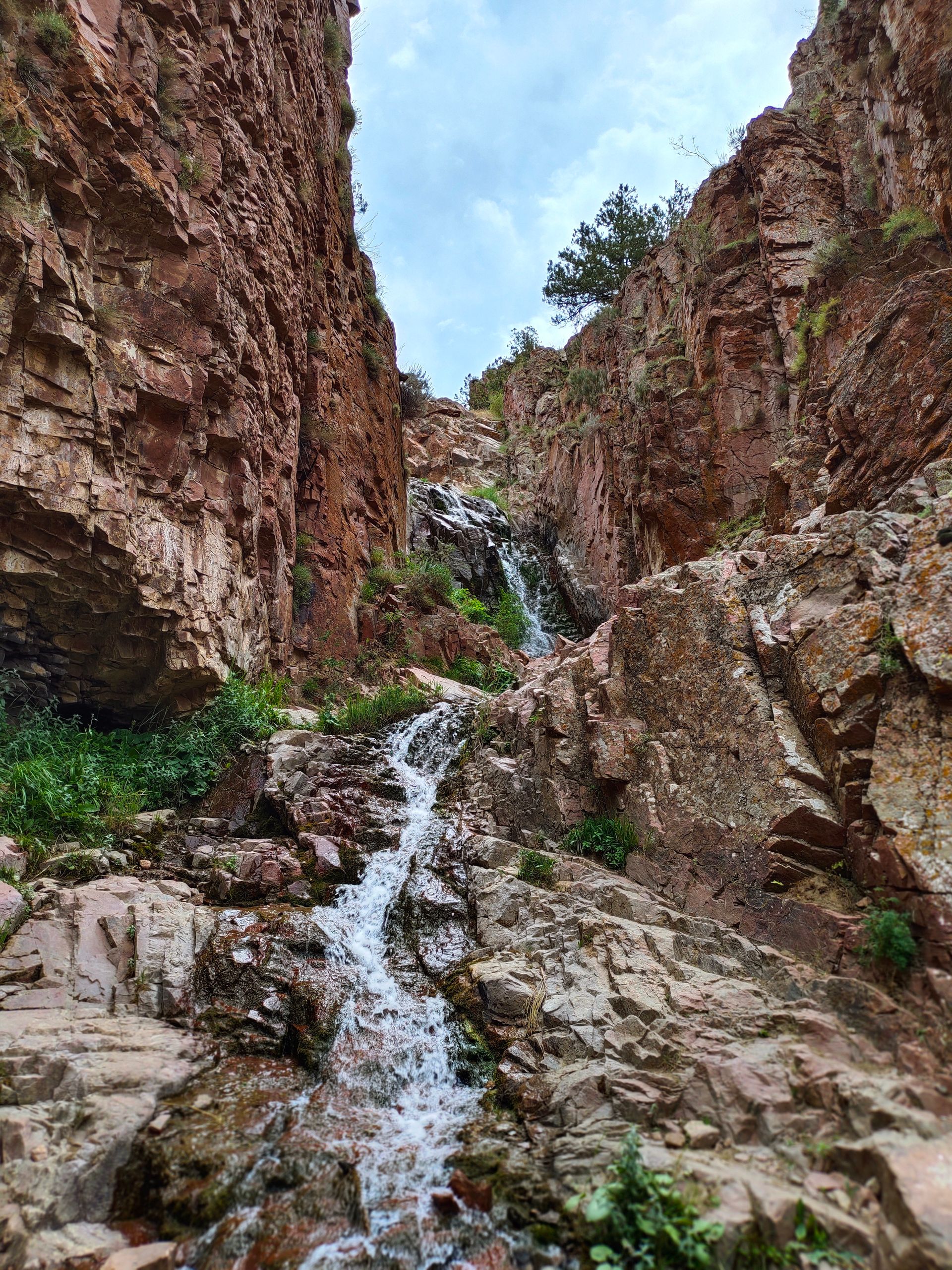 A tall waterfall cascading through a narrow canyon